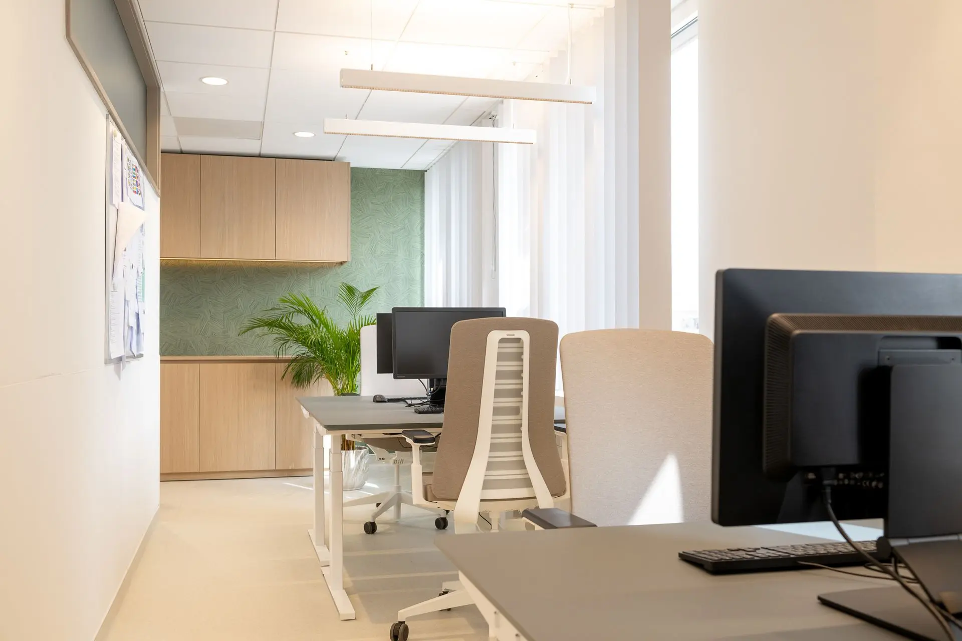 Ergonomisch ingerichte kantoorruimte met zit-sta bureaus en maatwerkkasten in de longartsenpraktijk van Sint-Truiden.