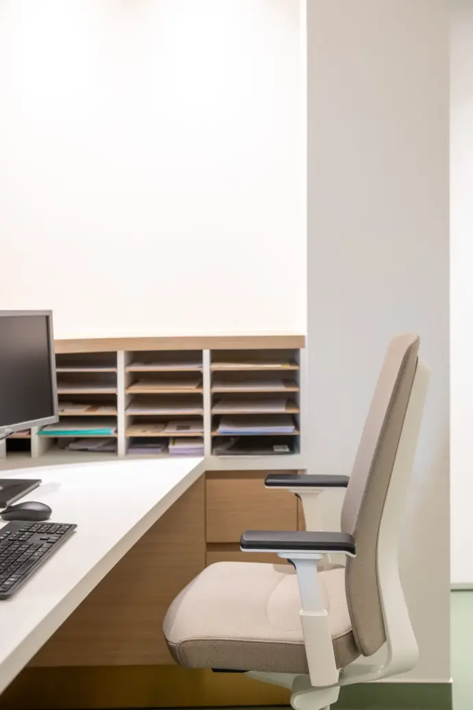 Ergonomische werkplek in de longartsenpraktijk van Sint-Truiden met een comfortabele bureaustoel en maatwerkbureau.