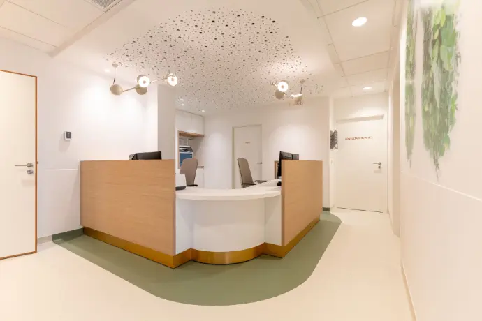 Centraal onthaal van de vernieuwde longartsenpraktijk in Sint-Truiden met een ergonomische en toegankelijke onthaalbalie.