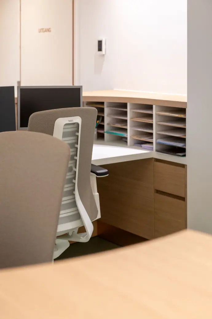 Ergonomische werkplek met maatwerkbureau, opbergruimte en comfortabele bureaustoelen in de longartsenpraktijk van Sint-Truiden.