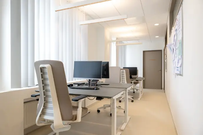 Ergonomische werkplekken met elektrische zit-sta bureaus in de vernieuwde longartsenpraktijk van Sint-Truiden.