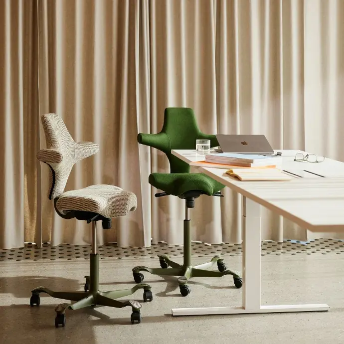 HÅG Capisco 8106 met moss frame – links Kvadrat Serpentine 0928, rechts GU Mandal 980 Black Forest Twee HÅG Capisco 8106 bureaustoelen, moss framekleur, links bekleding Kvadrat Serpentine 0928 en rechts GU Mandal 980 Black Forest