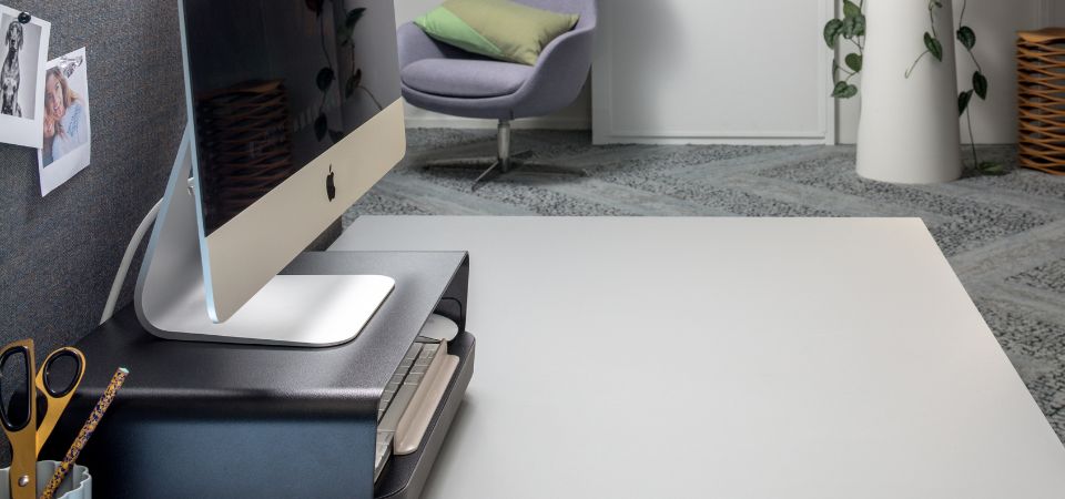 Apple computer op een zwarte Bento verstelbare monitorverhoger, met ergonomische toolbox voor een opgeruimde en ergonomische werkplek.