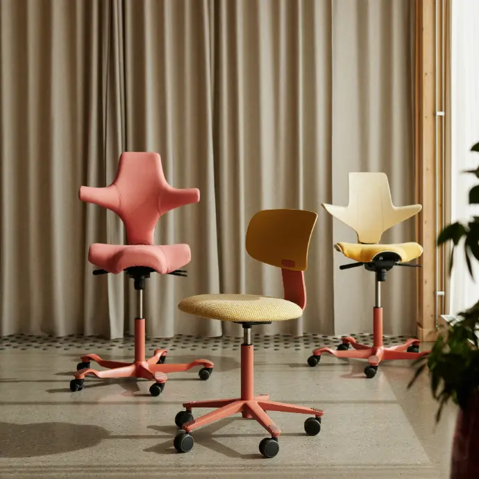 Capisco 8106, Tion 2140 en Capisco Puls 8020 in blush uitvoering met Kvadrat bekleding Drie HÅG stoelen met blush frame: links Capisco 8106 in Kvadrat Steelcut Quartet 0534, midden Tion 2140 met Harvest shell en Kvadrat Sisu 0405, rechts Capisco Puls 8020 met Sand shell en Kvadrat Steelcut Quartet 434